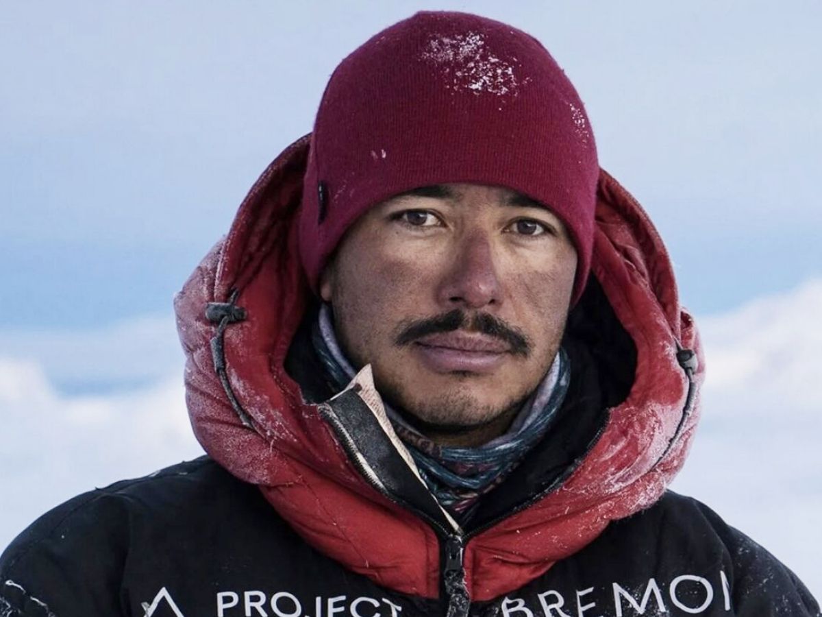 El alpinista nepalí Nirmal Purja sonriendo con su traje de alta montaña en una cumbre del Himalaya